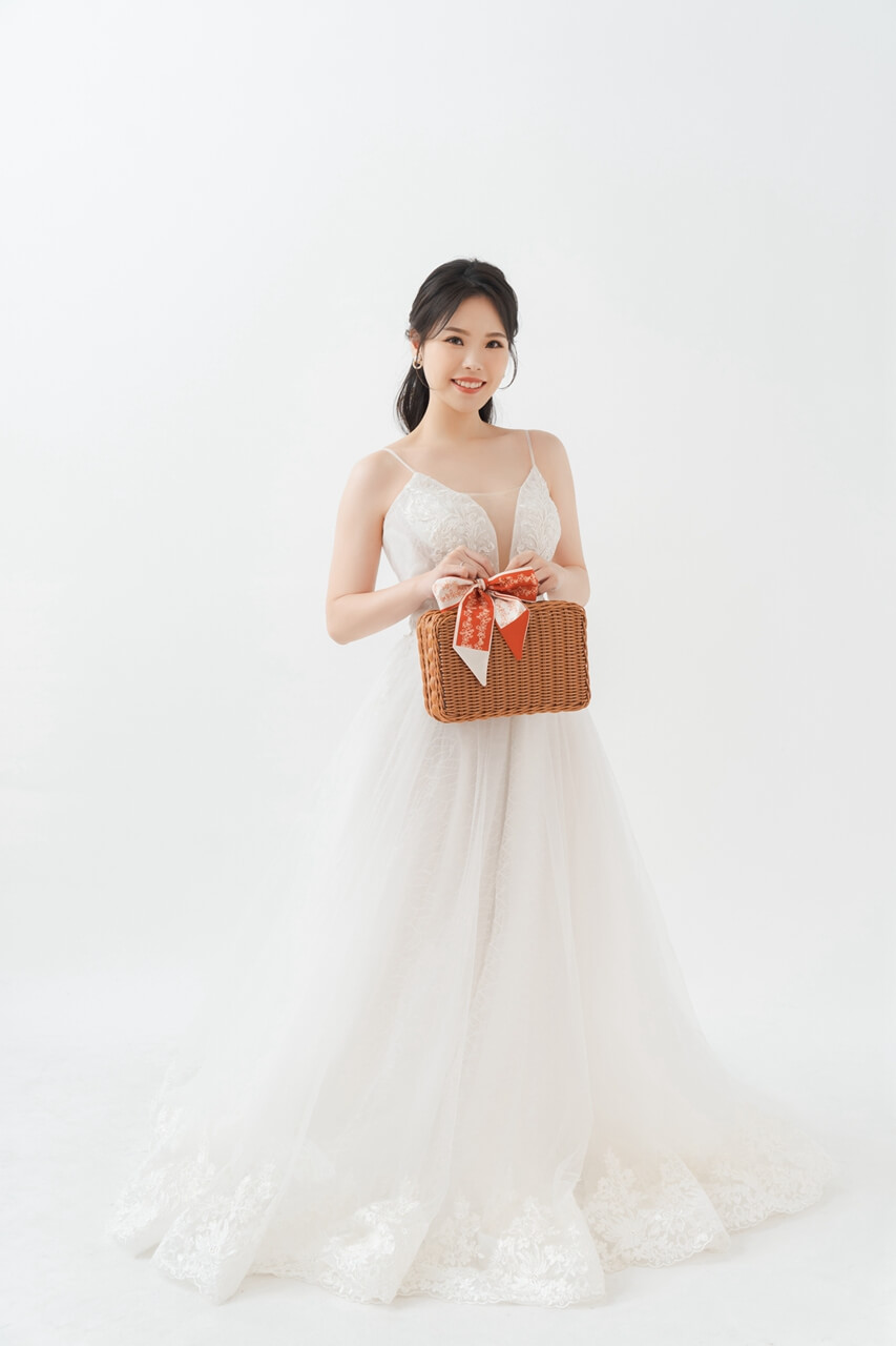 a woman in a white dress holding a basket